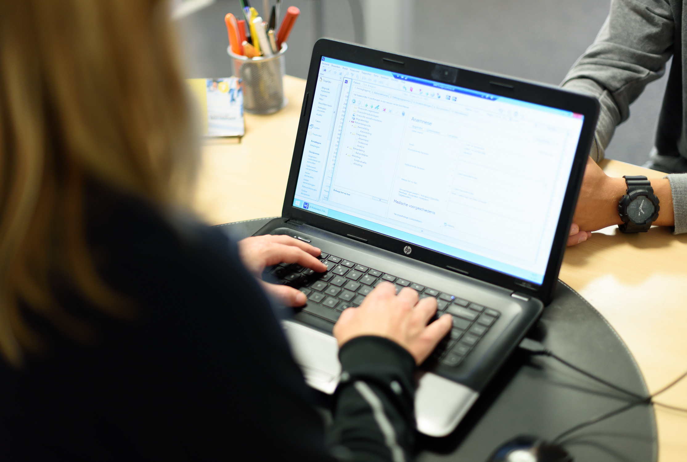 Een fysiotherapeut die de anamnese invult in Intramed