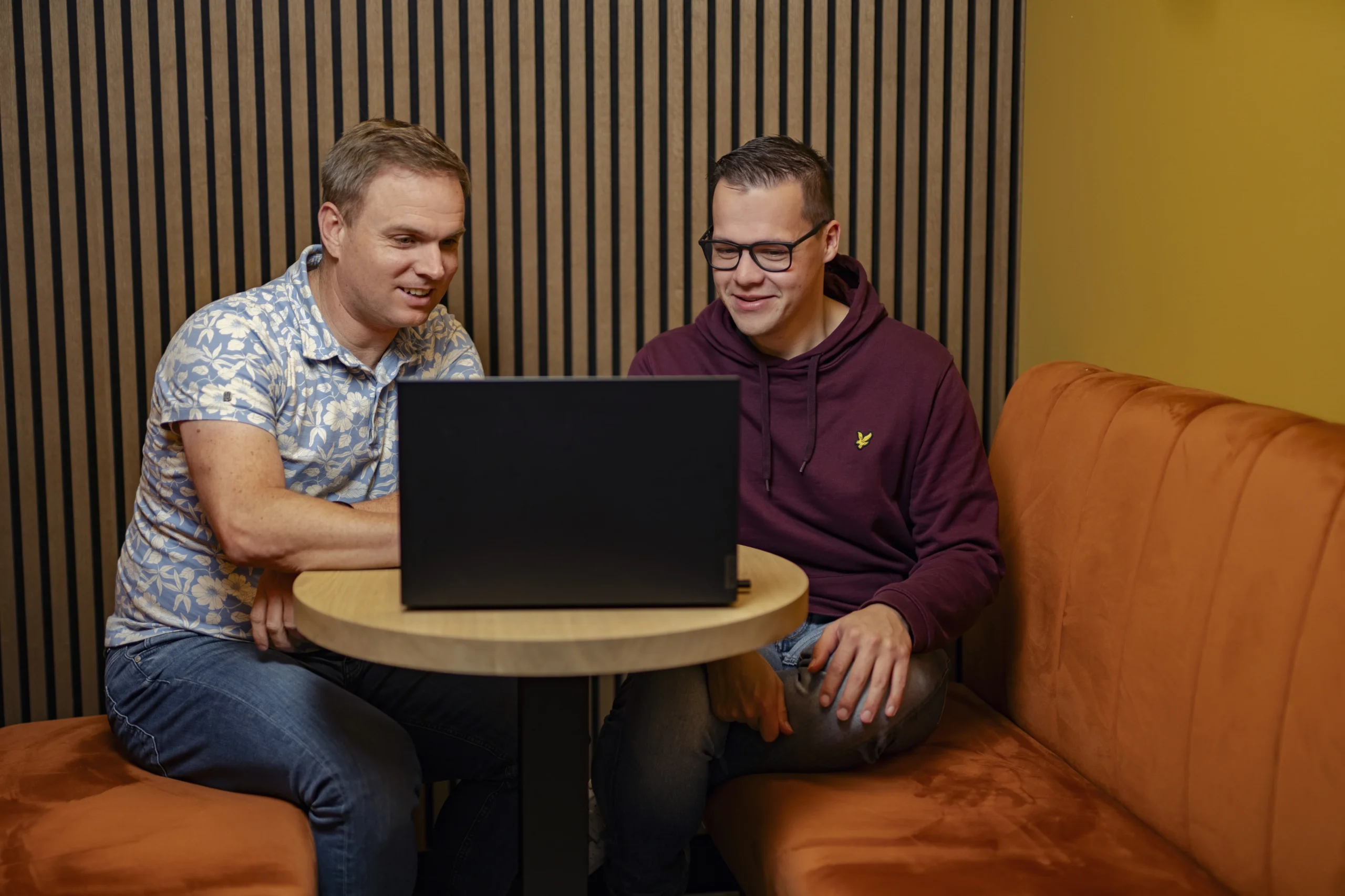 Twee personen die naar een laptop kijken