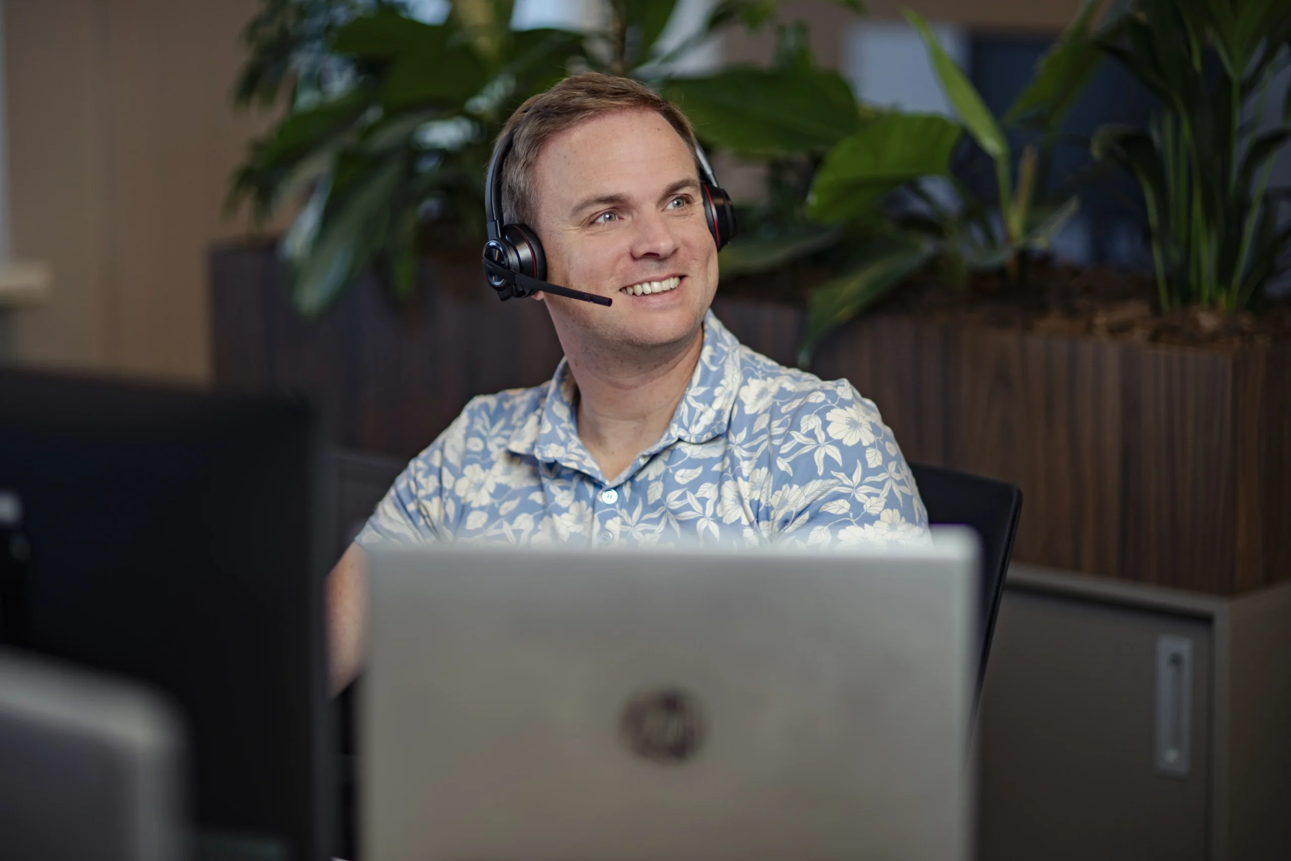 Medewerker van Intramed Service Centrum achter een laptop met een koptelefoon op