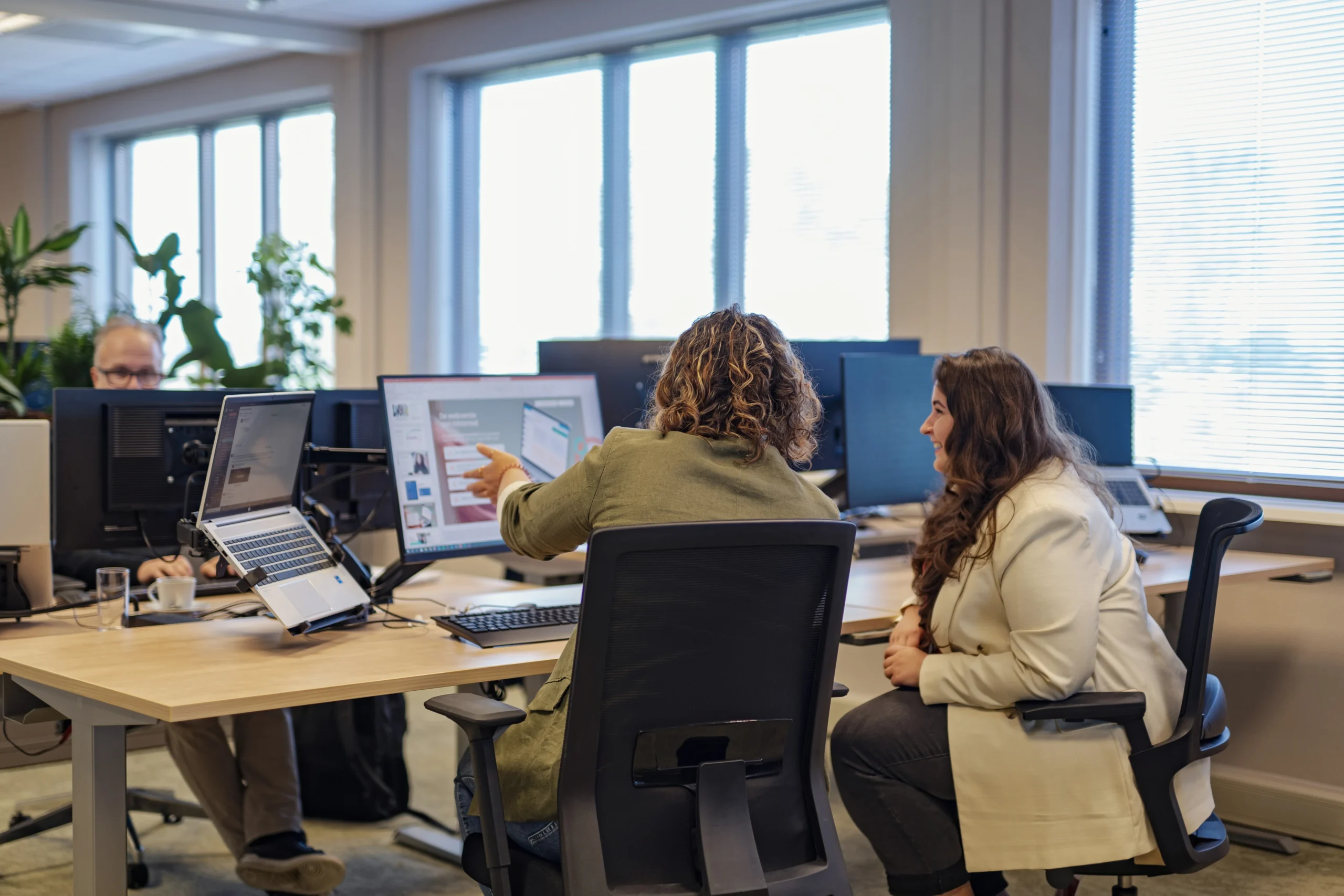 Twee medewerkers van Intramed werken samen op een computer